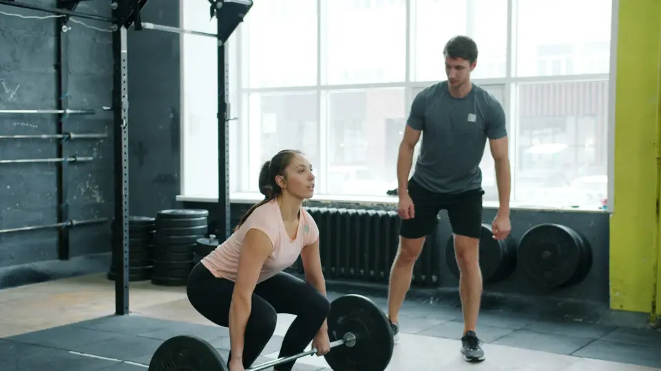 Trainer coaching a deadlift